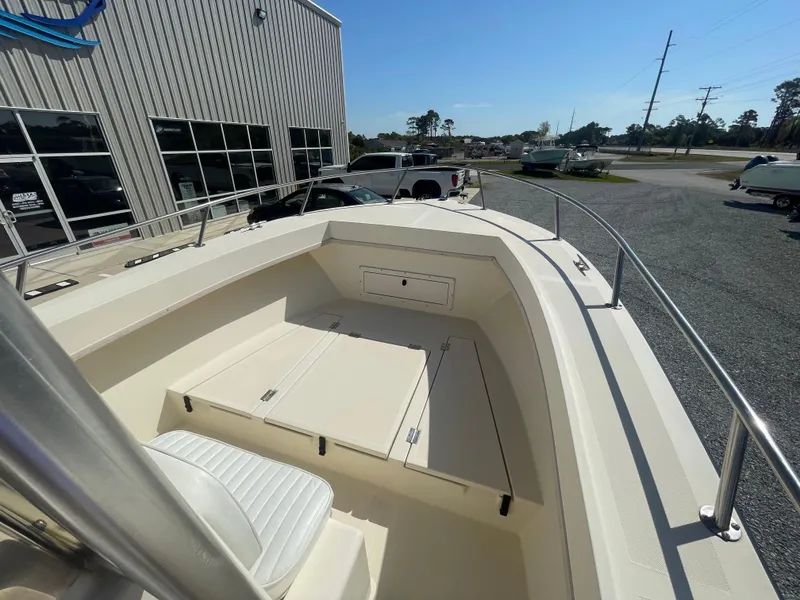 Slide: The Image of KenCraft Challenger 215 boat, 2000 model, docked near a building and parked vehicles. - 15