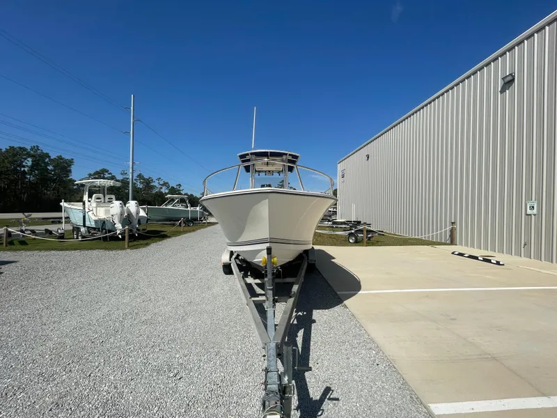 Slide: The Image of 2000 KenCraft Challenger 215 boat on trailer, parked outside a metal building under clear blue sky. - 2