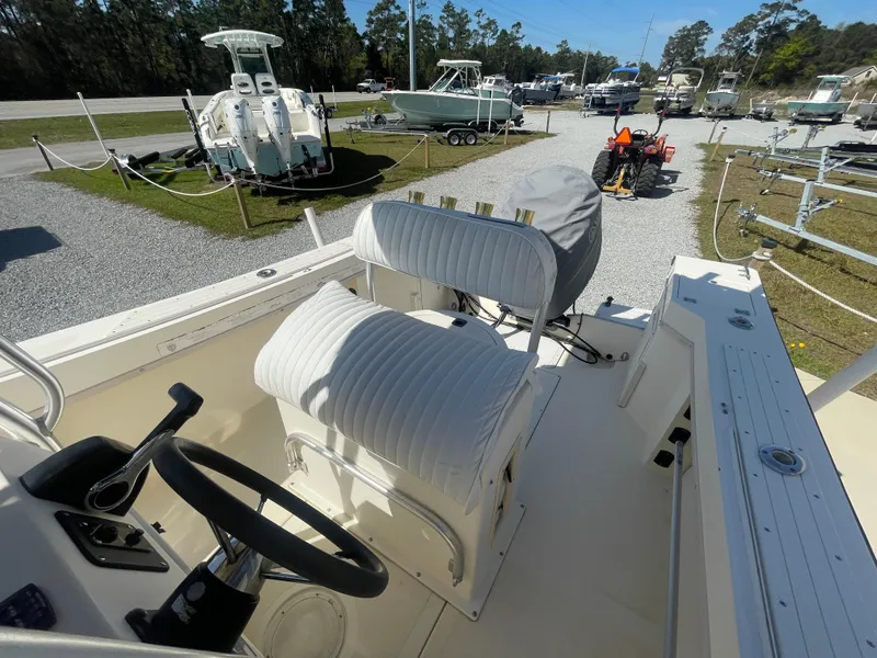 Slide: The Image of KenCraft Challenger 215 boat interior, 2000 model, with steering wheel and seating, in a boatyard. - 20