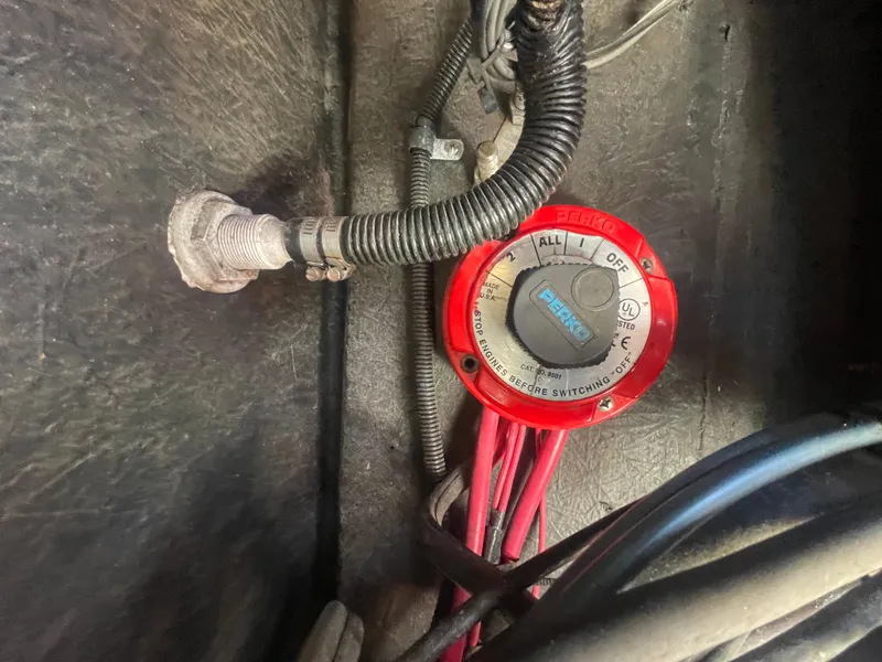 Slide: The Image of Battery switch in a 2000 KenCraft Challenger 215 boat, featuring red wiring and a Perko dial. - 22