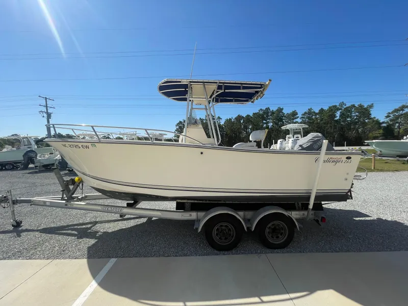 Slide: The Image of 2000 KenCraft Challenger 215 boat on trailer, parked outdoors under clear blue sky. - 4