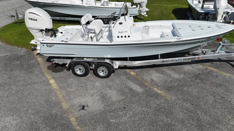 Slide: The Image of 2025 BlackJack 224 boat on trailer with Yamaha engine, parked on asphalt. - 19
