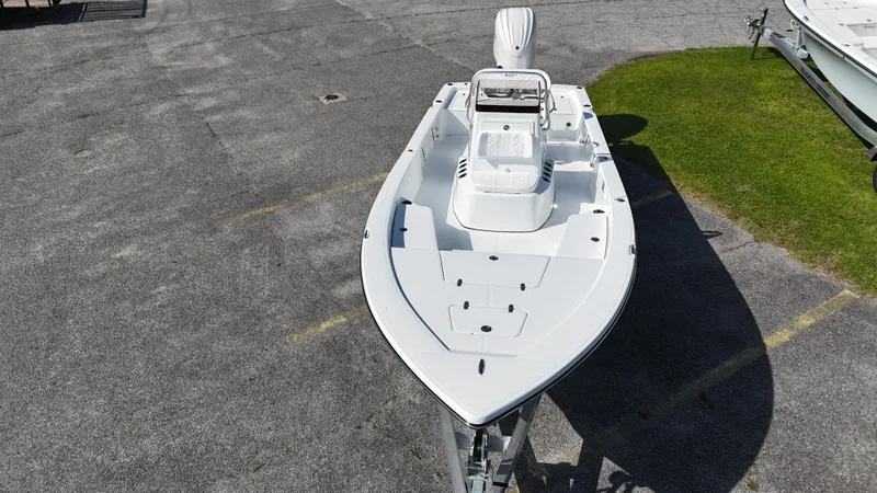 Slide: The Image of 2025 BlackJack 224 boat on pavement, aerial view, white hull, parked near grass. - 5