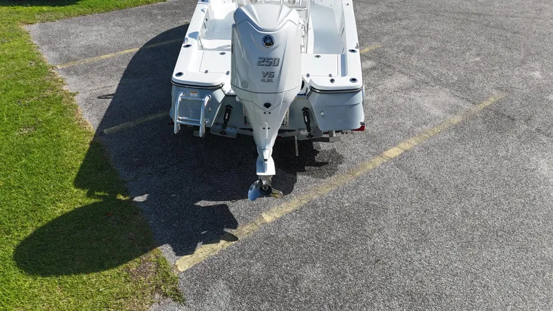 Slide: The Image of 2025 BlackJack 224 boat with powerful engine, parked on asphalt near grass. - 7