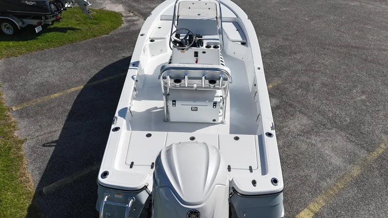Slide: The Image of 2025 BlackJack 224 boat, top view, white deck, parked on asphalt. - 8