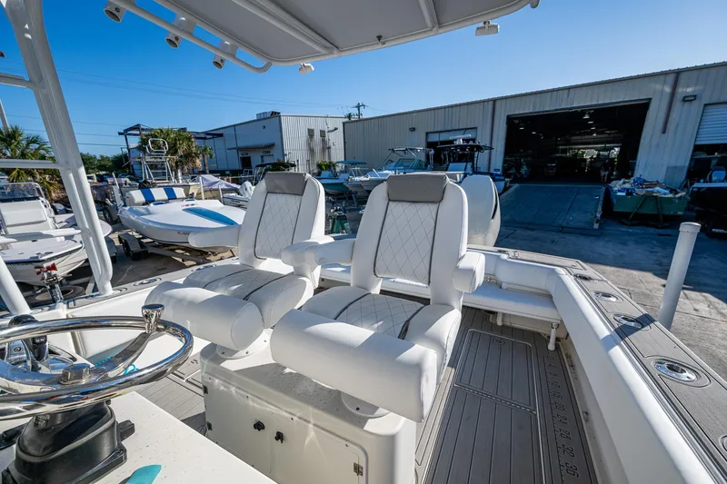 Slide: The Image of 2004 Salt Shaker 300 CC boat with dual white seats and steering wheel, docked near a warehouse. - 11