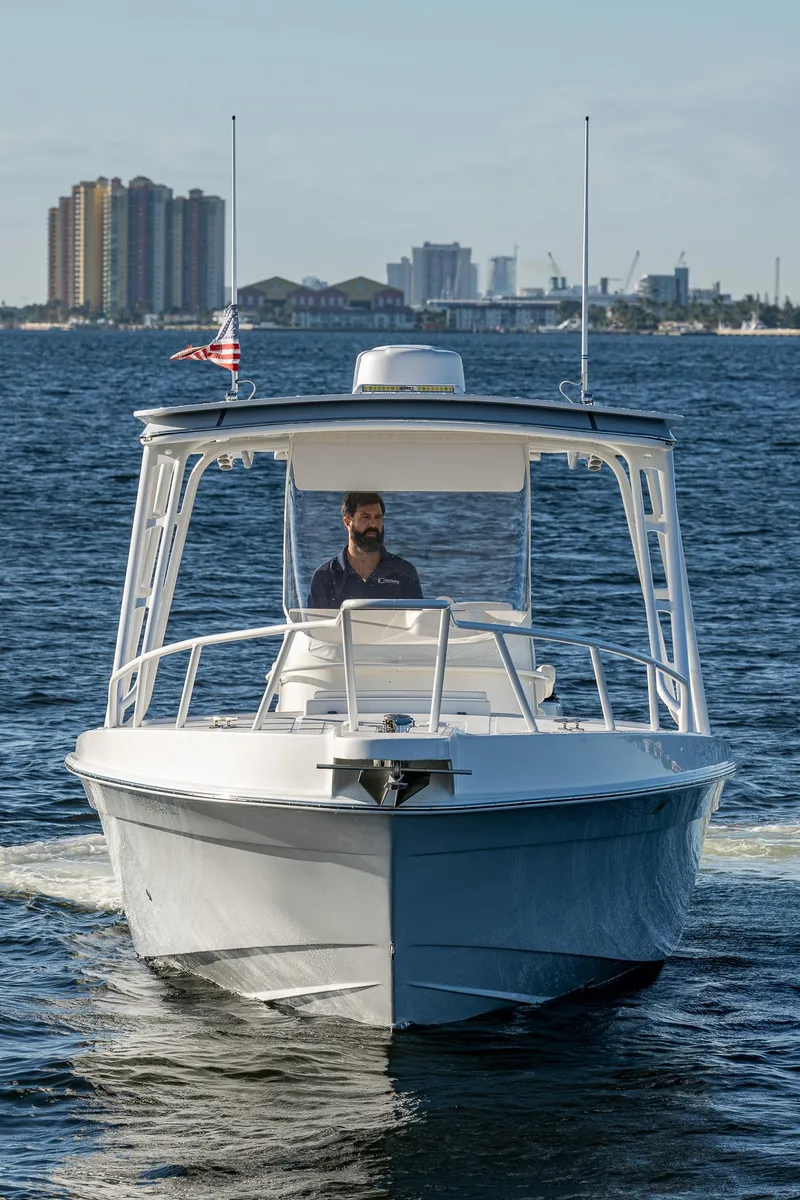 Slide: The Image of A 2004 Salt Shaker 300 CC boat cruising on the water with city skyline in the background. - 22