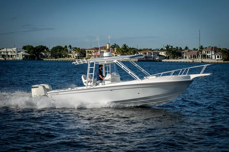 Slide: The Image of A 2004 Salt Shaker 300 CC boat cruising on a sunny day near coastal homes. - 23