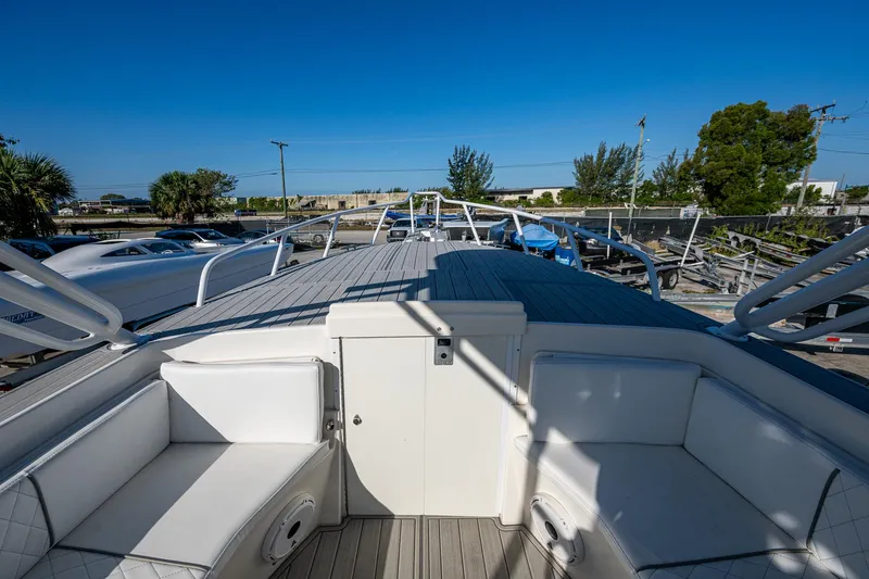 Slide: The Image of 2004 Salt Shaker 300 CC boat with spacious deck and seating, docked under clear blue sky. - 3