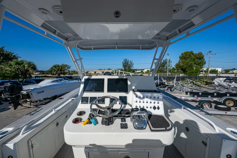 Slide: The Image of Cockpit view of a 2004 Salt Shaker 300 CC boat, featuring steering wheel and controls. - 8