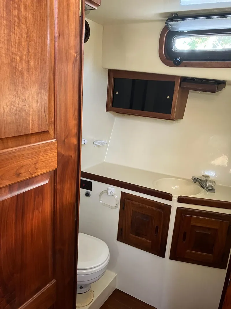 Slide: The Image of 1985 Wellcraft California boat bathroom with wooden cabinets and a compact design. - 10