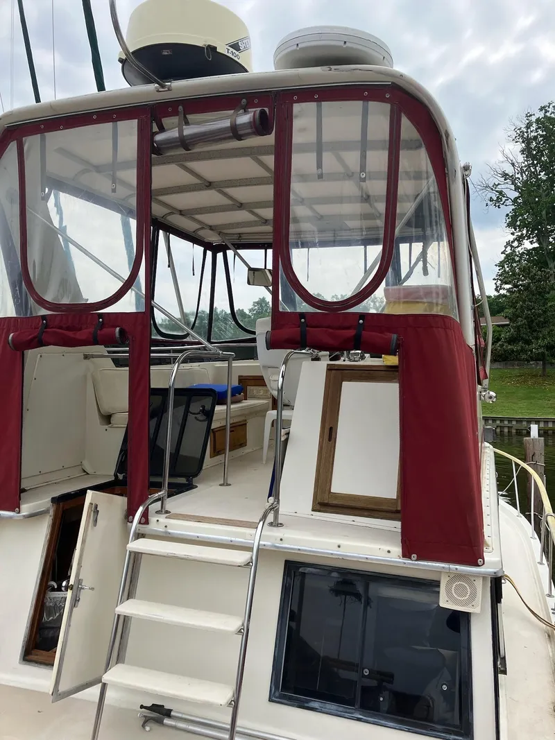 Slide: The Image of 1985 Wellcraft California boat with red canopy and ladder, docked near greenery. - 12