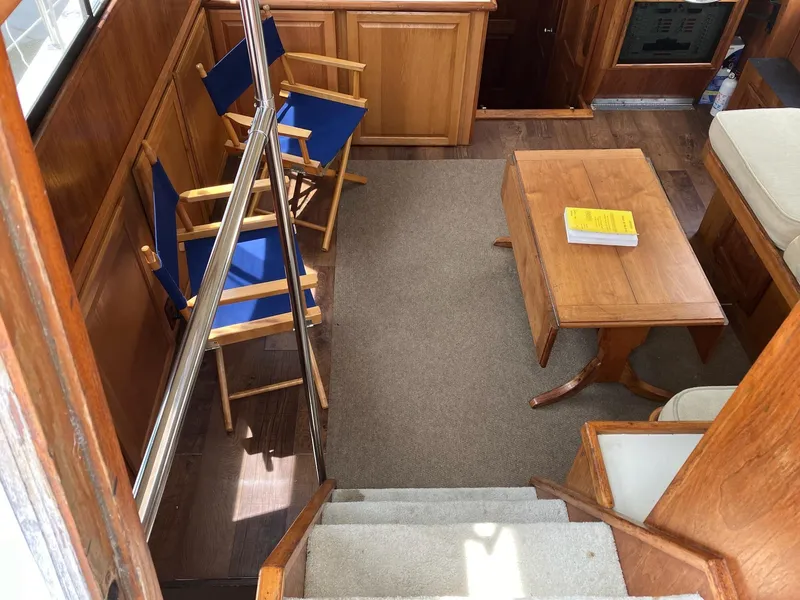 Slide: The Image of Interior of 1985 Wellcraft California boat with wooden furniture and blue chairs. - 13