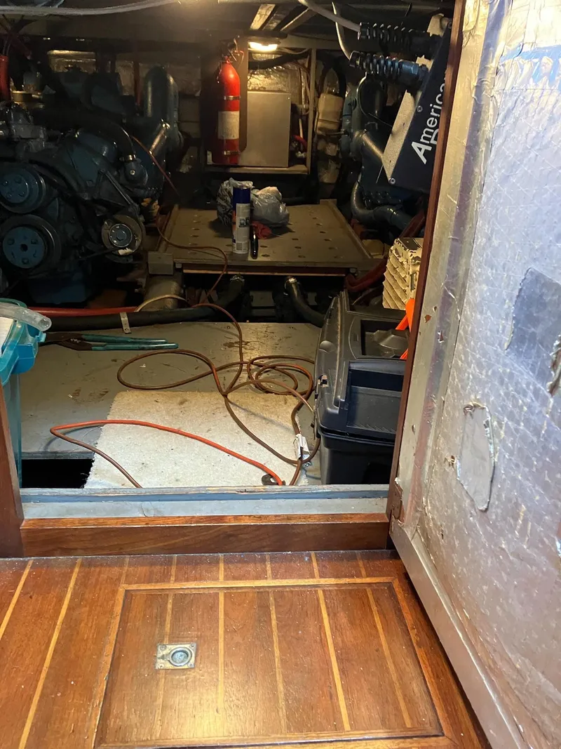 Slide: The Image of Engine room of a 1985 Wellcraft California boat, featuring mechanical equipment and wooden flooring. - 5