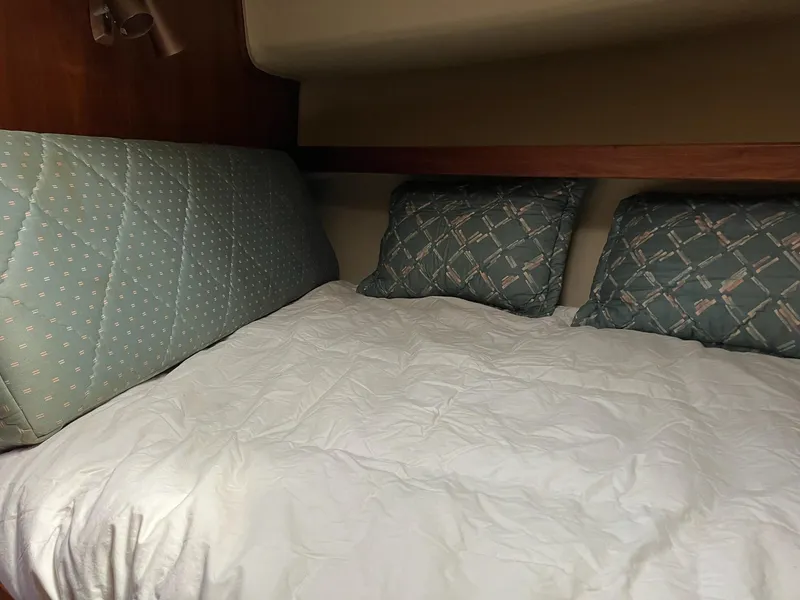 Slide: The Image of 1985 Wellcraft California boat cabin with cozy bedding and patterned pillows. - 7