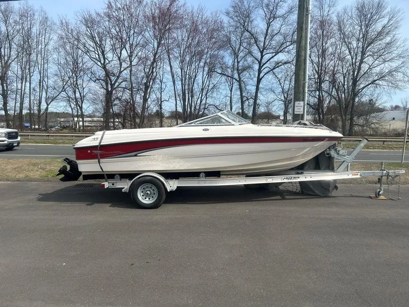 Slide: The Image of 2001 Chaparral 200 SSe boat on trailer, parked outdoors, with trees in the background. - 1