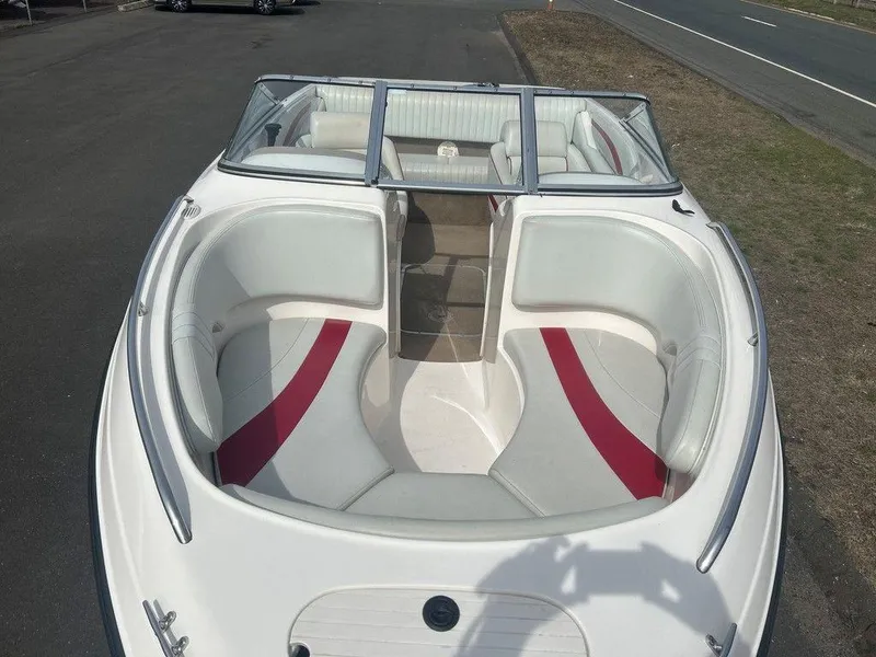 Slide: The Image of 2001 Chaparral 200 SSe boat with white and red interior, docked on pavement. - 4
