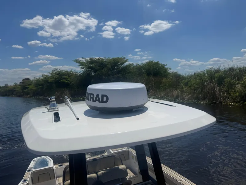 Slide: The Image of 2023 Yamaha Boats 255 FSH Sport E on water, featuring radar equipment under a clear sky. - 13