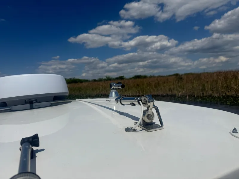 Slide: The Image of 2023 Yamaha Boats 255 FSH Sport E on water under blue sky with clouds. - 15