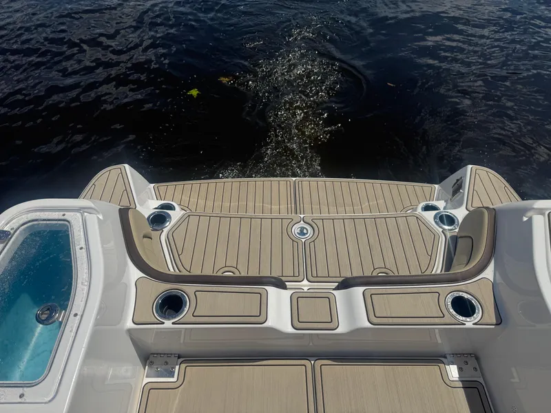 Slide: The Image of 2023 Yamaha Boats 255 FSH Sport E swim platform with cup holders and water view. - 17