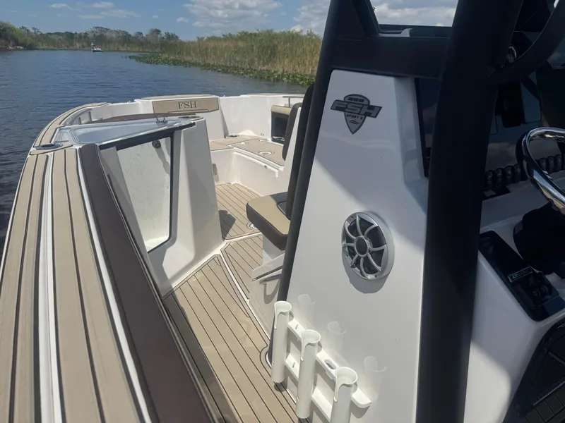 Slide: The Image of 2023 Yamaha Boats 255 FSH Sport E on a serene waterway, showcasing sleek design and features. - 18