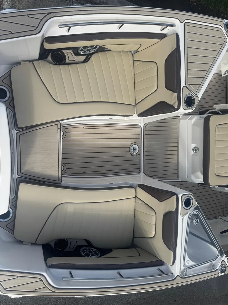 Slide: The Image of 2023 Yamaha Boats 255 FSH Sport E interior with beige seating and sleek design. - 25