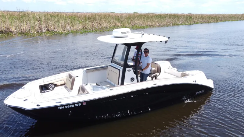 Slide: The Image of 2023 Yamaha Boats 255 FSH Sport E on calm water, featuring sleek design and modern amenities. - 3