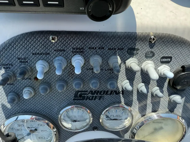 Slide: The Image of Control panel of a 2010 Carolina Skiff 218 ELV boat with switches and gauges. - 11