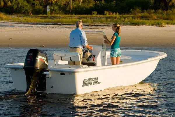 Slide: The Image of 2010 Carolina Skiff 218 ELV boat on water near sandy shore. - 13