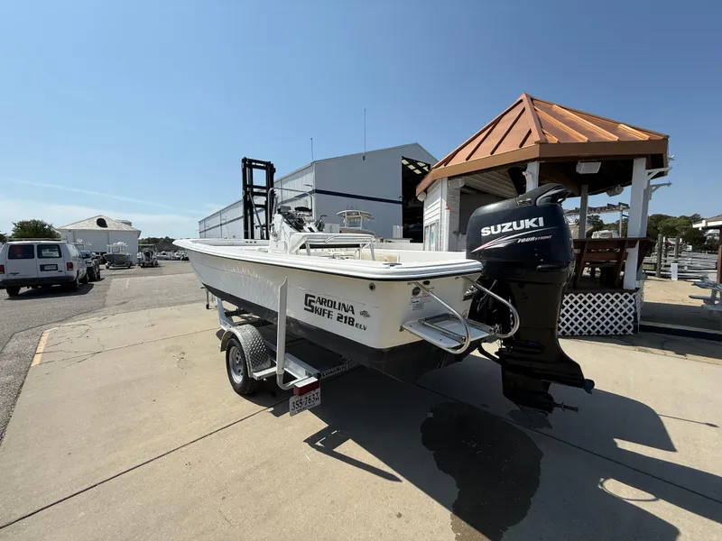 Slide: The Image of 2010 Carolina Skiff 218 ELV boat with Suzuki outboard motor on trailer, dockside. - 2