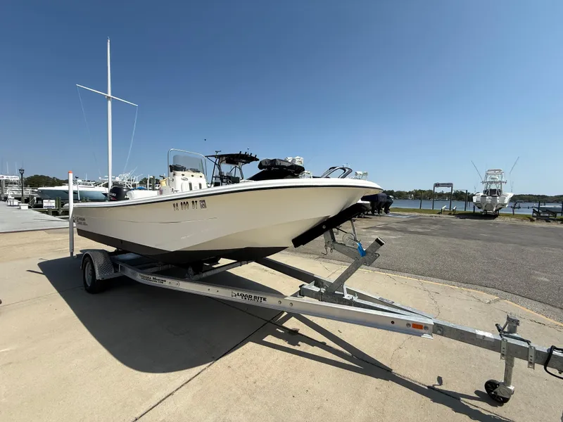 Slide: The Image of 2010 Carolina Skiff 218 ELV boat on trailer at marina under clear blue sky. - 6