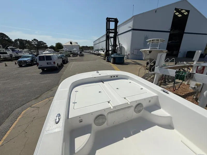 Slide: The Image of 2010 Carolina Skiff 218 ELV boat at marina with parked vehicles and storage building. - 7
