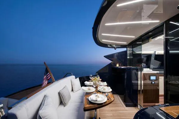 Slide: The Image of Luxurious 2023 Lazzara LSX yacht deck with elegant dining setup at sunset. - 11