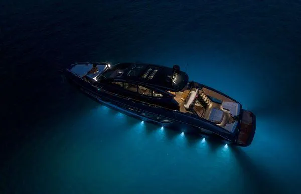 Slide: The Image of 2023 Lazzara LSX yacht illuminated at night, showcasing sleek design and underwater lights. - 3