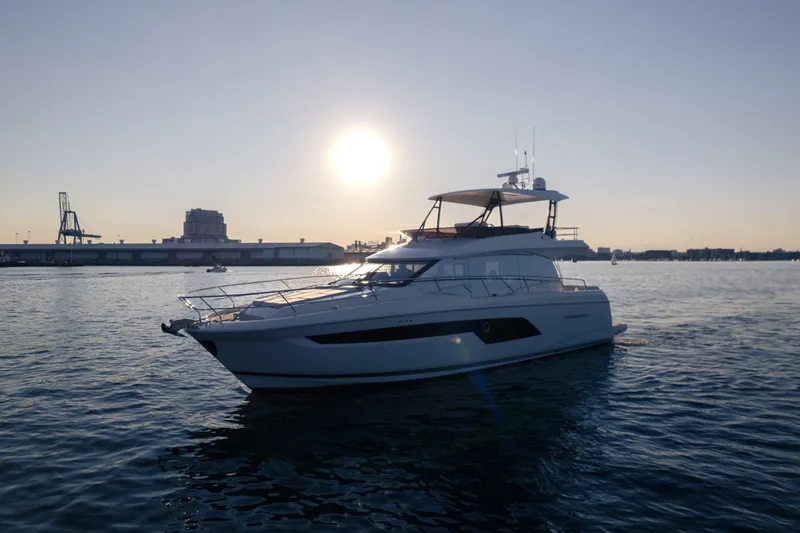 Slide: The Image of 2023 Prestige 520 F-Line yacht on calm water at sunset. - 1