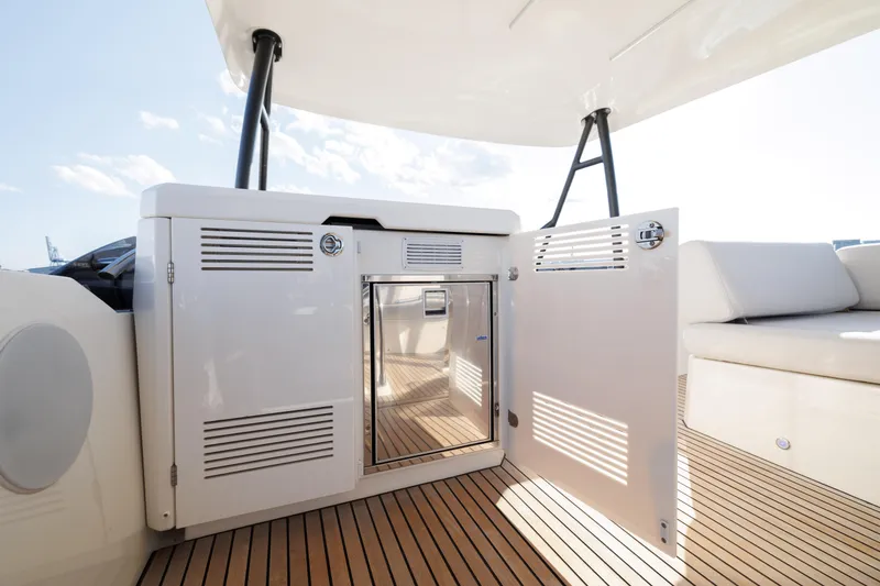 Slide: The Image of 2023 Prestige 520 F-Line yacht deck with open storage compartment and seating area. - 11