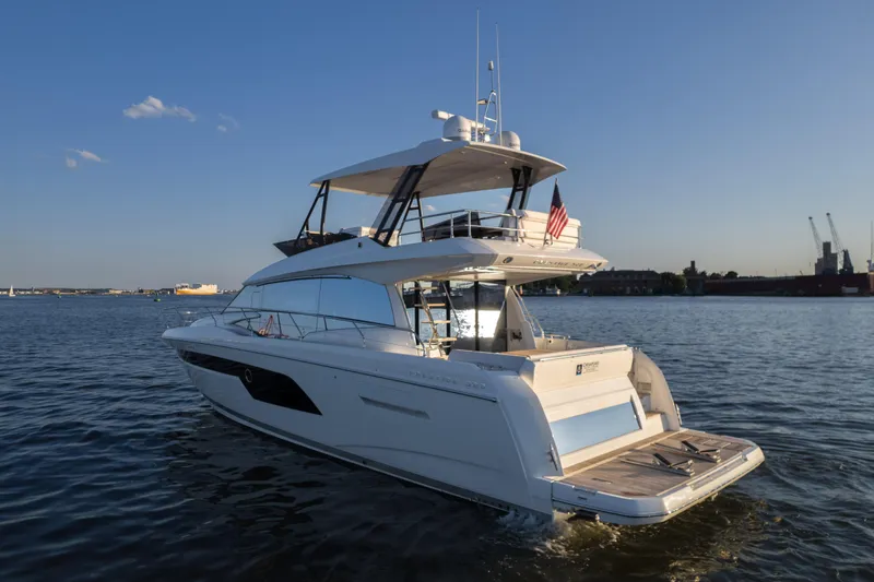 Slide: The Image of 2023 Prestige 520 F-Line yacht cruising on calm waters at sunset. - 2