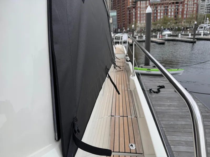 Slide: The Image of Side deck of 2023 Prestige 520 F-Line yacht at marina, featuring sleek design and wood finish. - 36