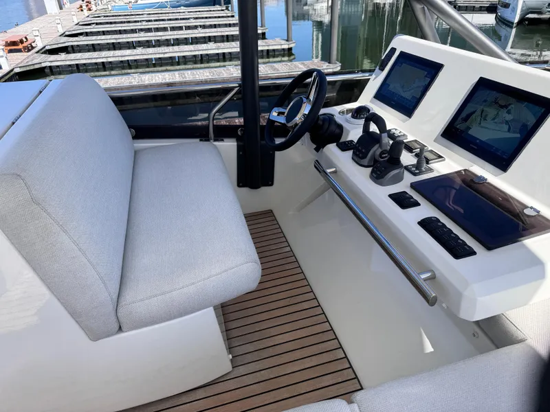 Slide: The Image of 2023 Prestige 520 F-Line yacht helm with dual screens and cushioned seating. - 8