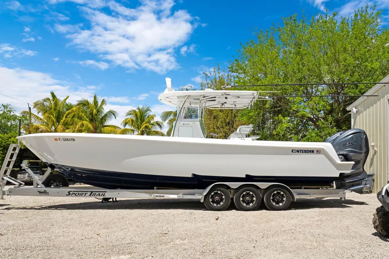 Slide: The Image of 2024 Contender 35 ST boat on trailer, parked outdoors under blue sky. - 3