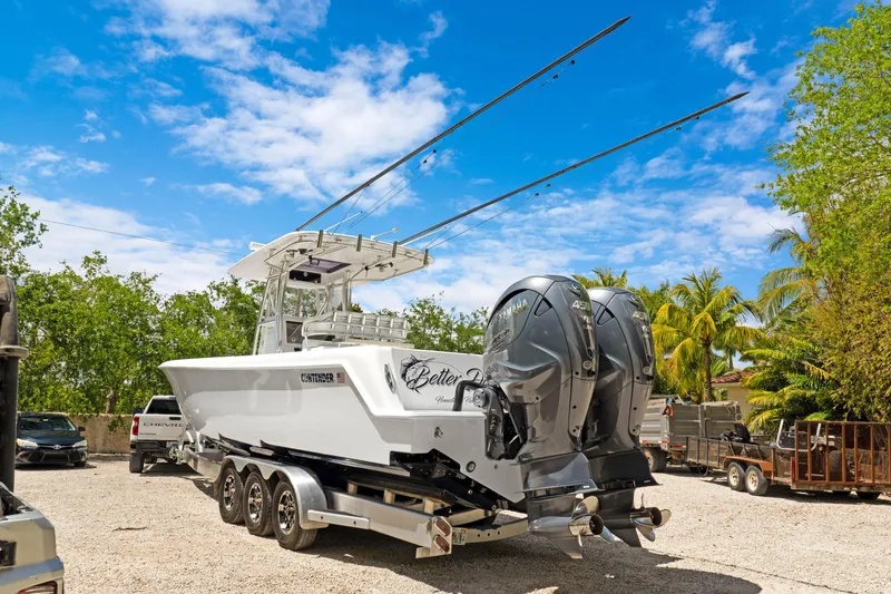 Slide: The Image of 2024 Contender 35 ST boat on trailer, dual engines, parked outdoors under blue sky. - 4