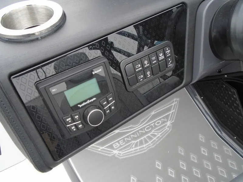 Slide: The Image of 2025 Bennington M Swingback 24 MSB dashboard with control panel and cup holder. - 12