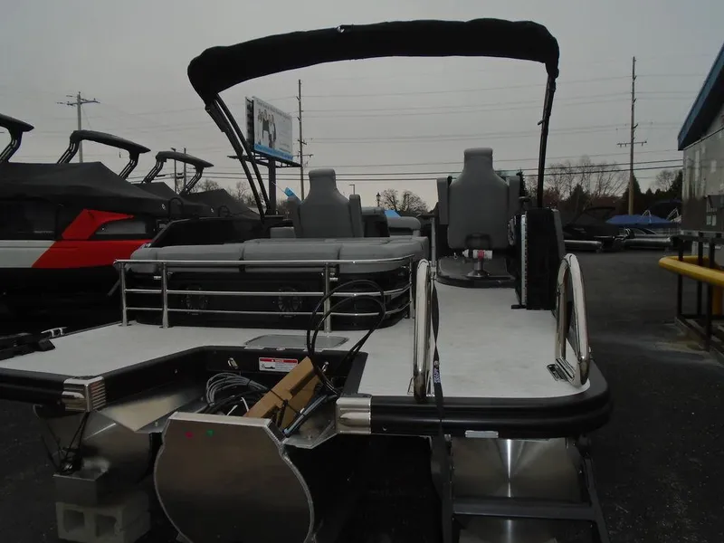 Slide: The Image of 2025 Bennington M Swingback 24 MSB pontoon boat with seating and canopy, displayed outdoors. - 29