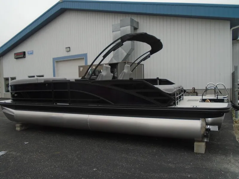 Slide: The Image of 2025 Bennington M Swingback 24 MSB pontoon boat, black exterior, parked outside a building. - 31
