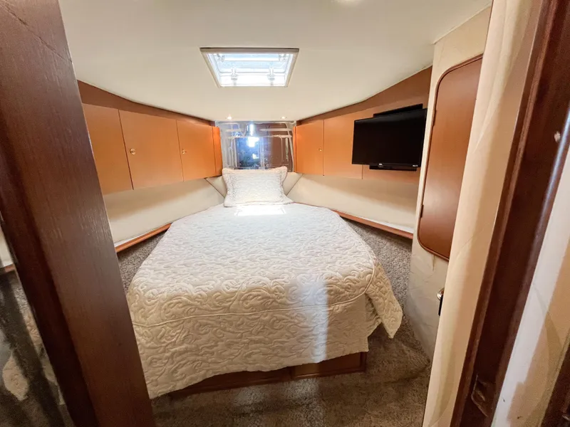 Slide: The Image of Luxurious bedroom in 2002 Ocean Yachts 48 Super Sport with cozy bed and TV. - 15
