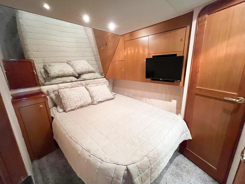Slide: The Image of Luxurious cabin interior of 2002 Ocean Yachts 48 Super Sport with cozy bed and TV. - 17
