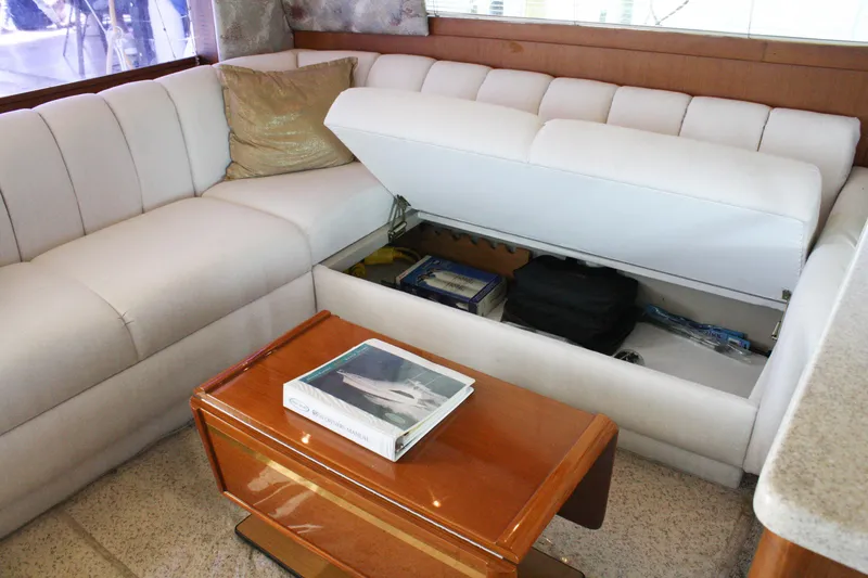 Slide: The Image of Luxurious 2002 Ocean Yachts 48 Super Sport interior with white sofa and wooden table. - 32