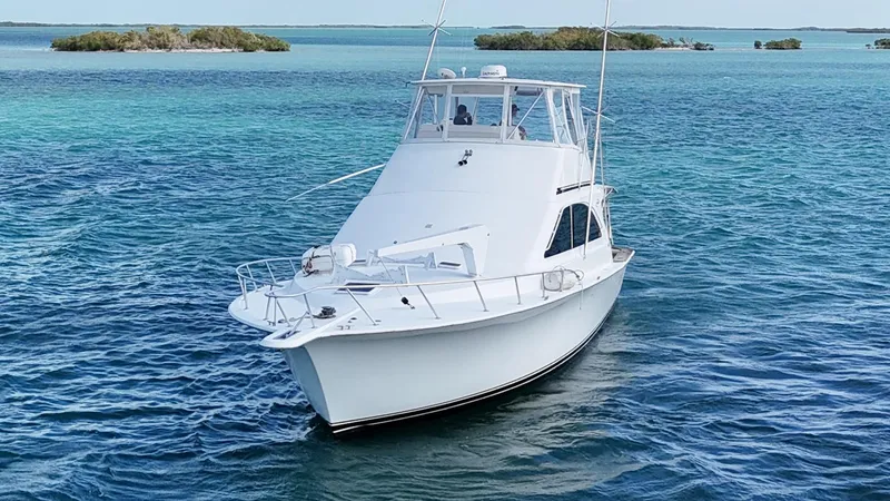 Slide: The Image of 2002 Ocean Yachts 48 Super Sport on clear blue water, near small islands. - 6