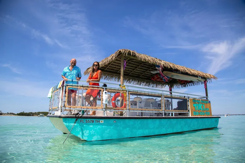 Slide: The Image of 2022 Beachcat COI Tiki Boat on clear water, featuring a thatched roof and vibrant design. - 11