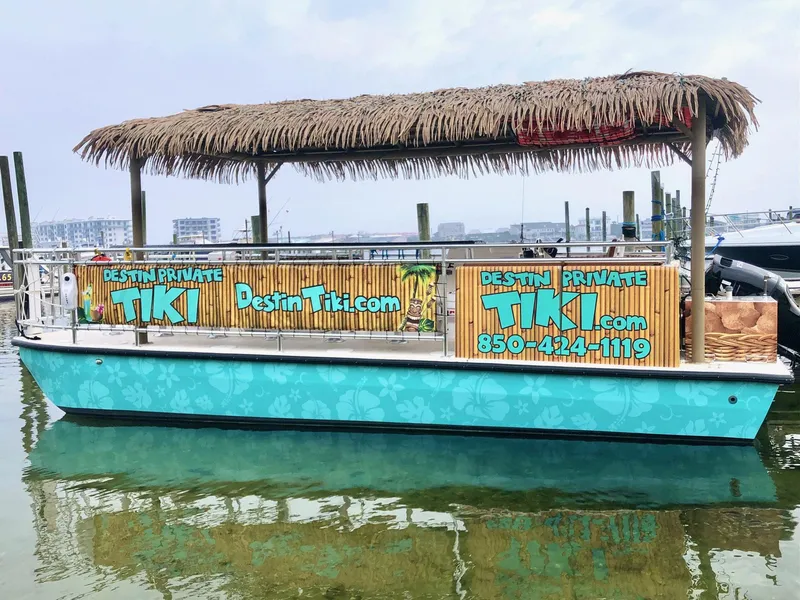 Slide: The Image of Tiki-themed 2022 Beachcat COI Tiki Boat with bamboo decor and thatched roof on calm water. - 4